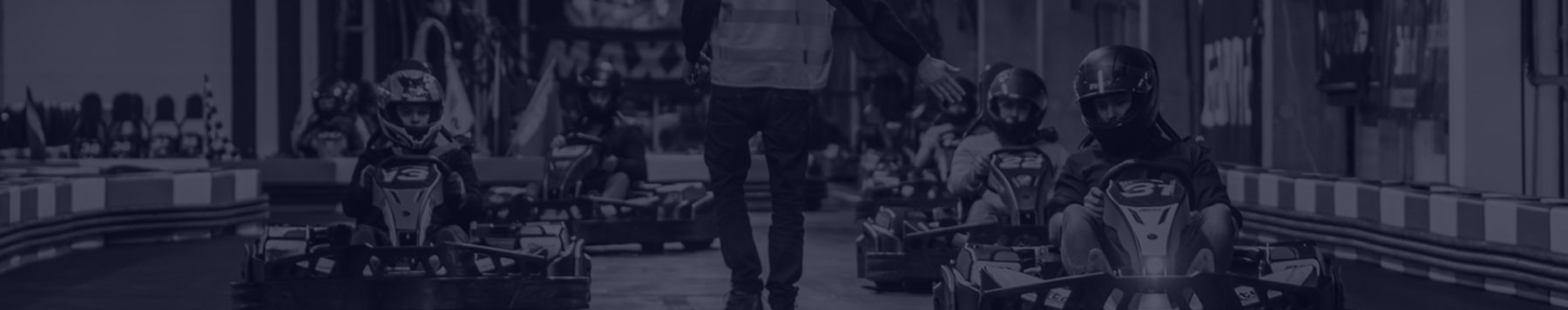 Brede panoramafoto van de kartbaan met karts in de pitstraat, zeer geschikt als header.